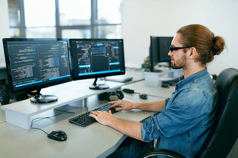 编程. 在IT办公室工作的人，坐在办公桌前写代码. 软件开发公司的程序员，在项目中输入数据代码. 高质量图像.