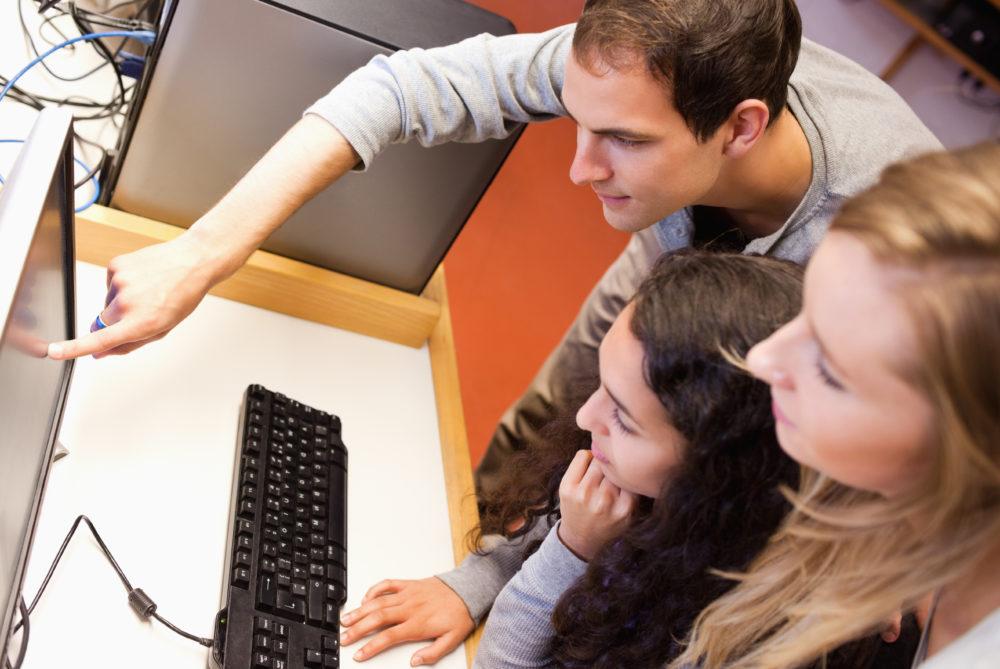 Fellow students using a computer in an IT room